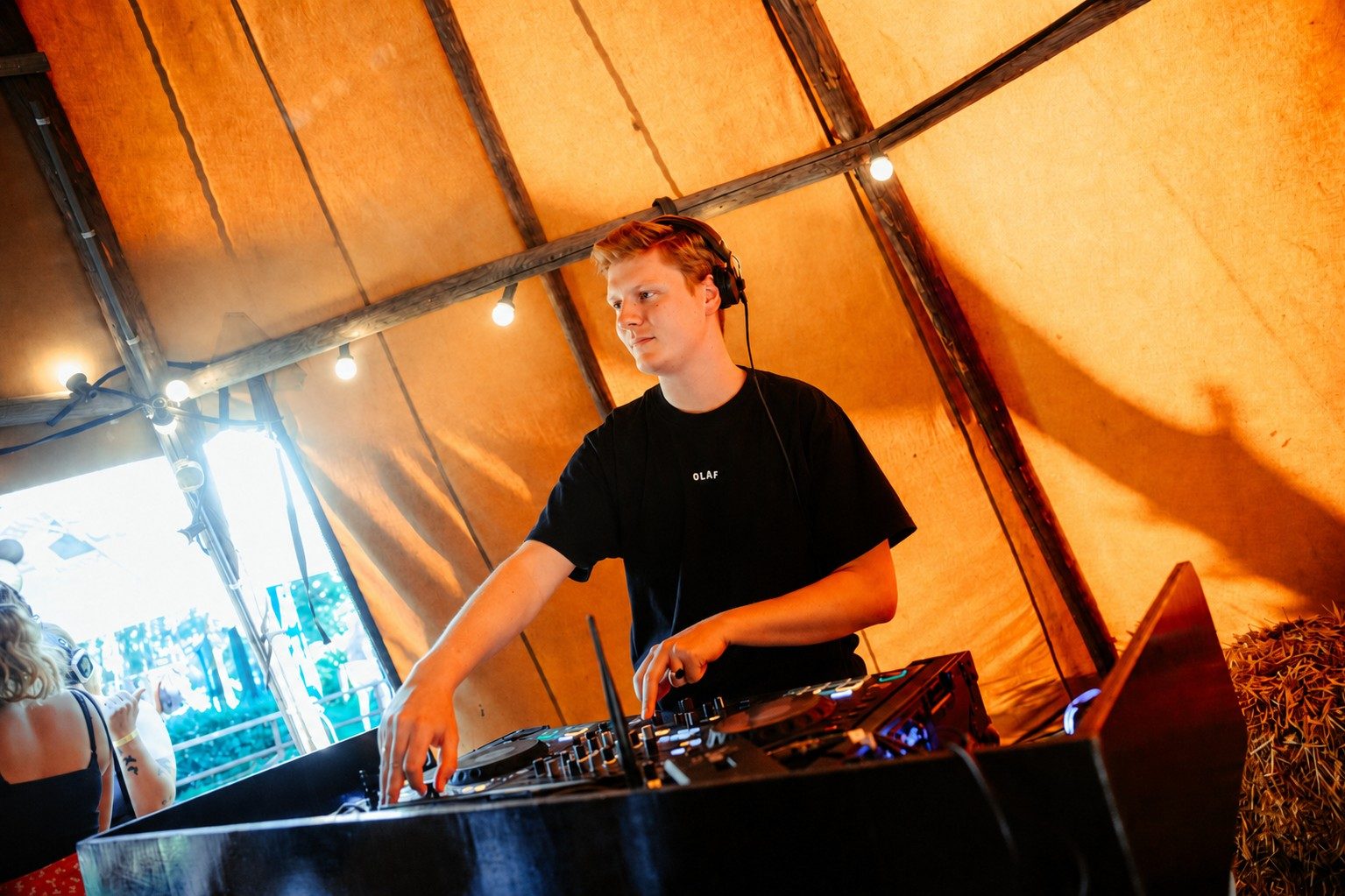 DJ Surleau achter de decks in een warme festivaltent