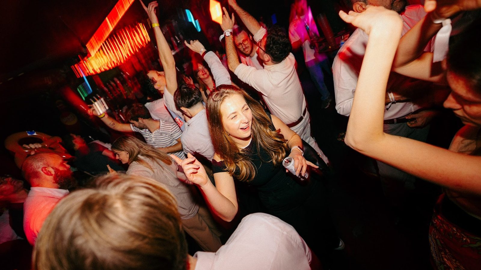 Nachtelijke feestsetting met dansend publiek en gekleurde lichten